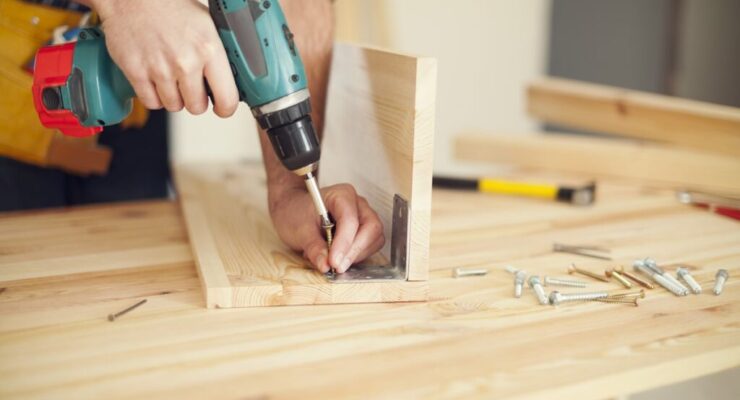 close-up-carpenter-working-with-drill-min